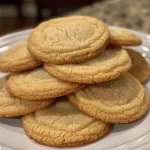 Warm sugar cookies on a wooden surface, showcasing their soft texture.