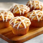 Close-up of a delicious apple pie cupcake topped with whipped cream and cinnamon.