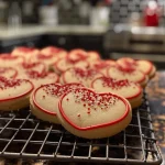 A side view of freshly baked Valentine sugar cookies, displaying their soft texture and vibrant icing.