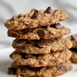 Delicious vegan chocolate chip cookies with a golden brown hue and a few chocolate chips visible.