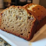 A close-up view of a slice of 3-ingredient banana bread, showing its moist texture and golden crust.