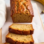 Close-up of moist banana bread with a golden crust and a soft texture.