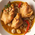 Close-up of expertly cooked pigs feet garnished with parsley, showcasing a rich sauce and tender meat.