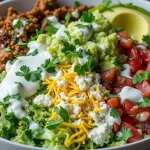 Delicious low carb burrito bowl with various toppings like ground meat, guacamole, lettuce, tomato, and cheese.