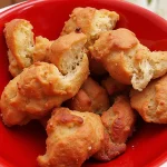 Close up of monkey bread pieces in a red bowl.