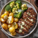 Garlic butter steak plated with broccoli and potatoes