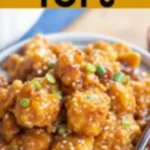 Close-up of honey garlic tofu in a bowl garnished with sesame seeds and green onions.