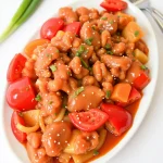 Sweet and Sour Chicken plated on a white platter.