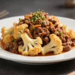 Plate of cauliflower with ground meat sauce.