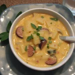 Bowl of Cajun potato soup garnished with herbs on a grey plate.