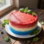 A beautifully decorated red, white, and blue ombré cake from Edgar's Bakery, showcasing layers of vibrant colors.