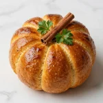 Freshly baked sourdough ginger pumpkin bread sliced on a wooden cutting board.