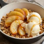 A close-up of a gluten-free and vegan apple crisp served in a white bowl with a golden crumble topping.