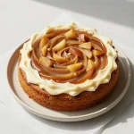 A freshly baked vegan applesauce cake topped with powdered sugar on a wooden table.