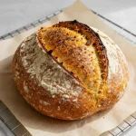 Freshly baked pumpkin sourdough bread on a wooden cutting board